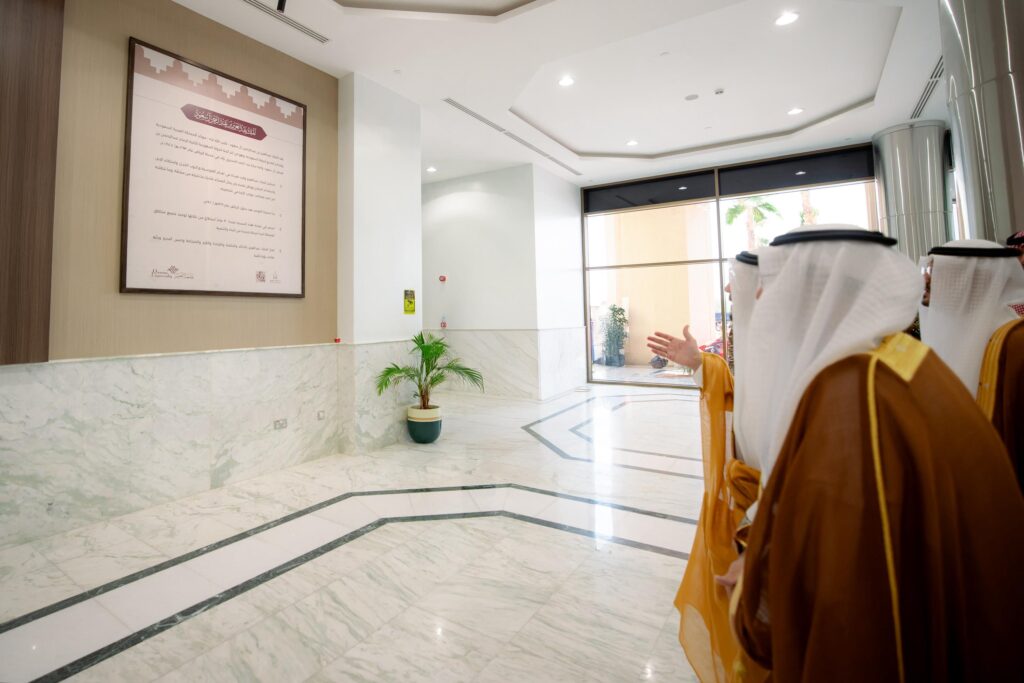 مسؤولون يتفقدون وثيقة رسمية خلال احتفال الجامعة باليوم الوطني في رد جامعة القصيم.