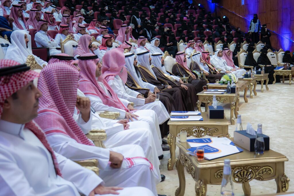 An official academic presence at the Qassim University Tamouh program in a festive atmosphere.