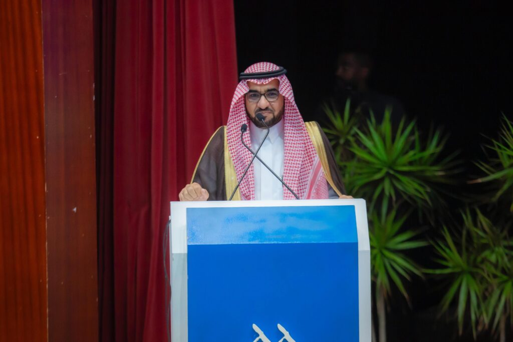 Delivering a speech on academic regulations for new students at Qassim University.