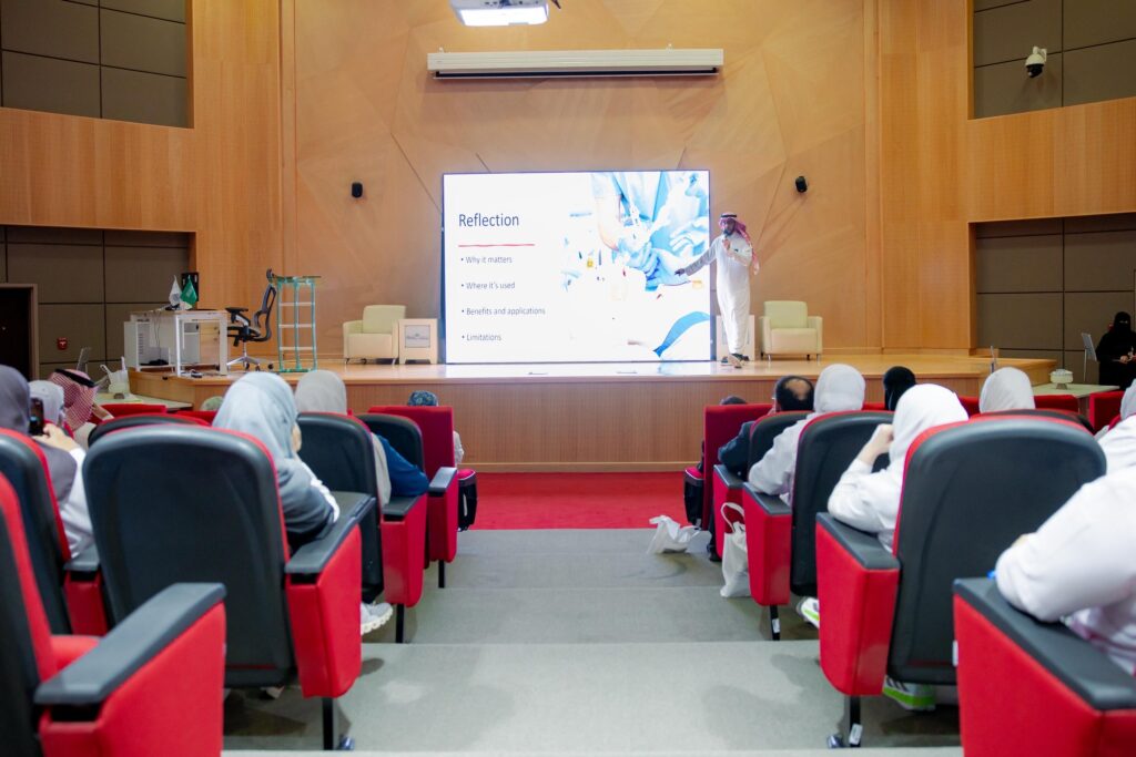 A lecturer gives a presentation titled Reflection during the Global Simulation Week at Qassim University.