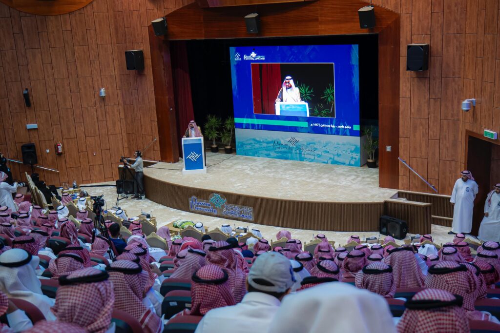 A speaker addresses new students at Qassim University Hall as part of an official welcome event.