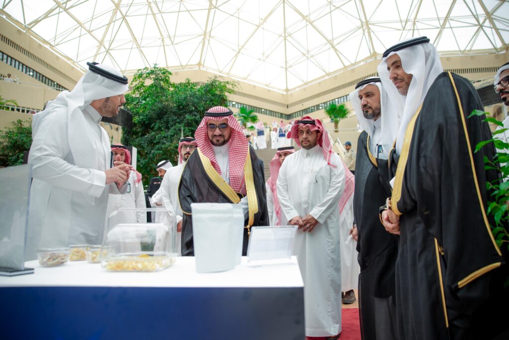 Participants discuss food samples at the Qassim Exhibition as part of World Space Week.