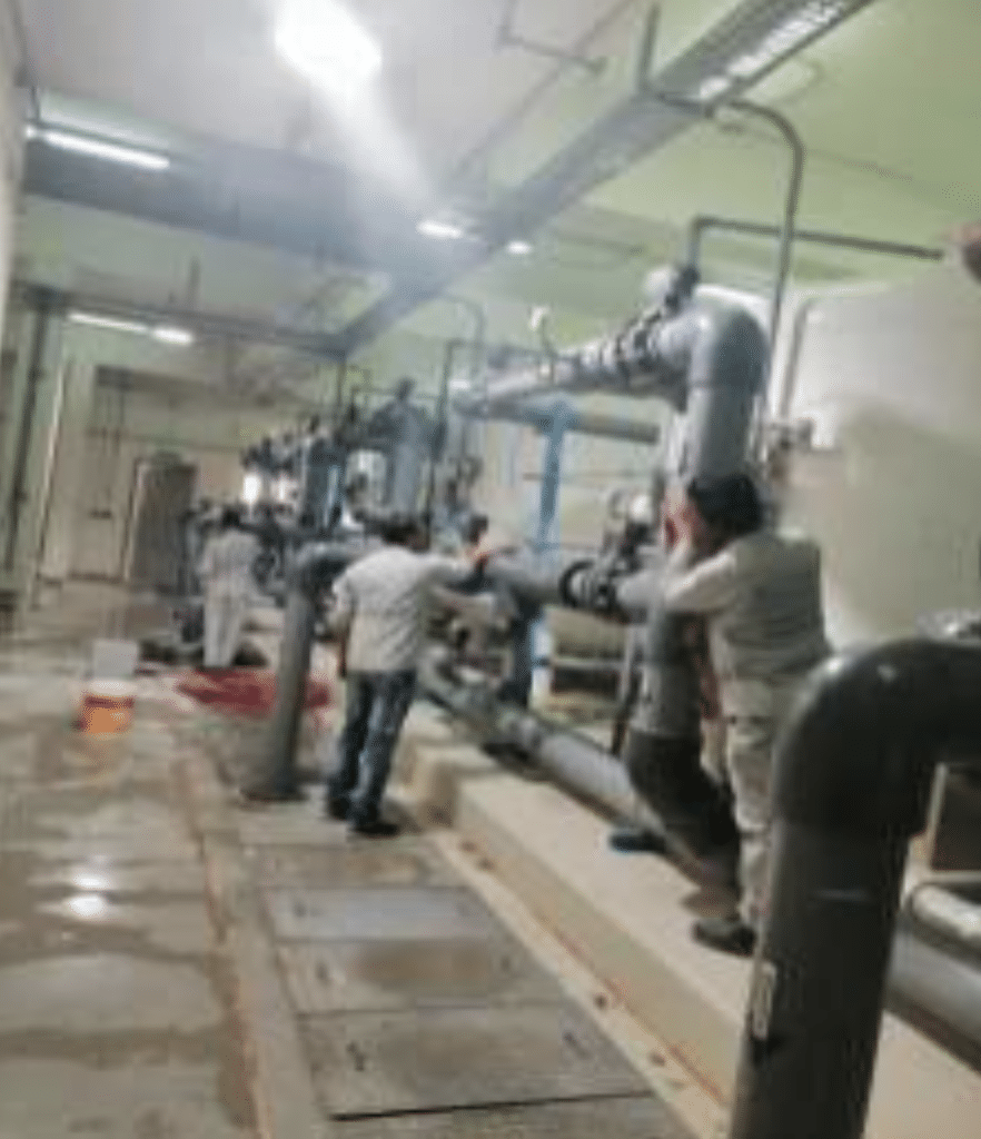 A team supervises sewage treatment pipes at a university facility at Qassim University.