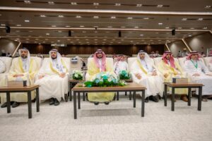 Attending the World Teacher's Day celebration at Qassim University Hall in a formal academic atmosphere.
