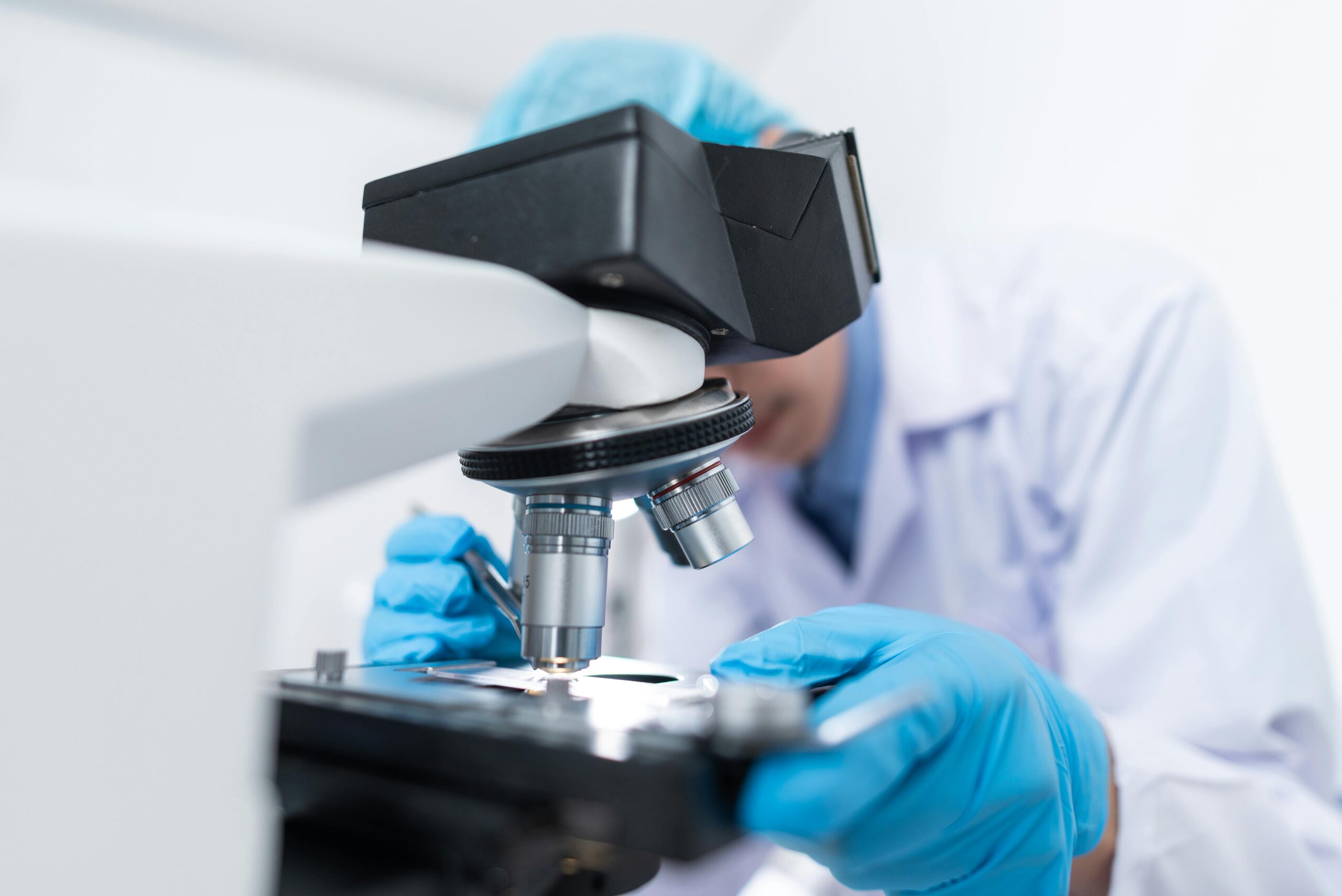 A researcher at the Qassim University Laboratory Laboratory conducts a microscopic examination of a specimen in an academic setting.