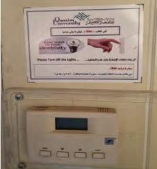 A digital controller under a sign at Qassim University that raises awareness of the importance of rationalizing energy according to the values of the Muslim community.