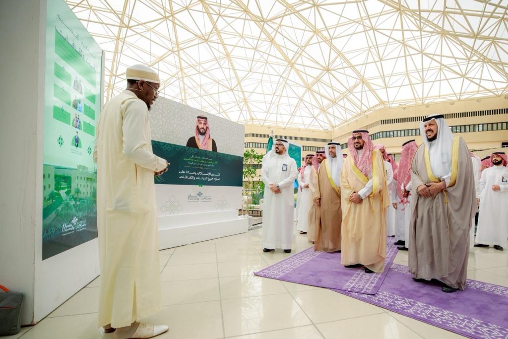 An official scene at a tender exhibition at Qassim University shows interaction between members of the academic community.