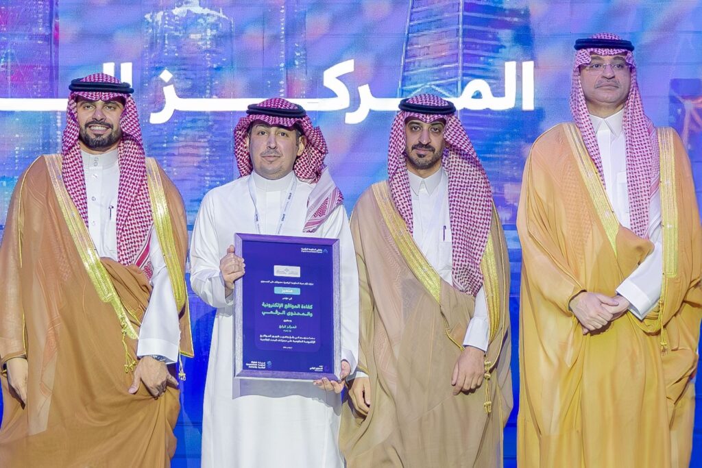 Honoring an academic at Qassim University in the presence of faculty members and honoring an outstanding student on the podium.