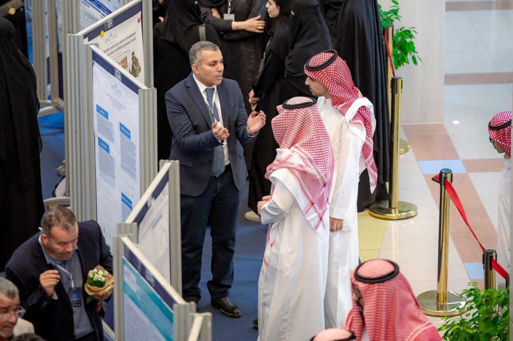 Attending the Scientific Research Forum 2025 at Qassim University and exchanging academic discussions among the participants.