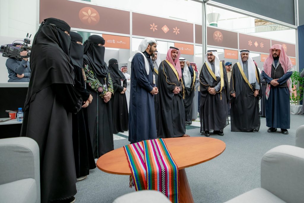 تجمع لمجموعة من الأكاديميين بجامعة القصيم للاطلاع على اليدوية خلال مؤتمر علمي.