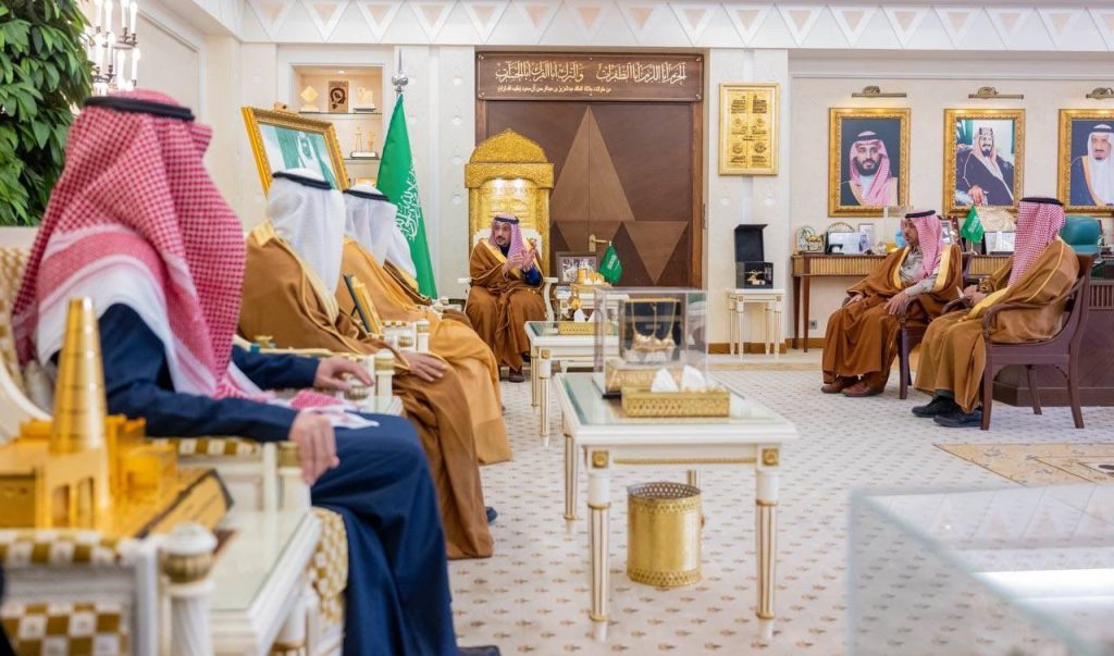 اجتماع رسمي في قاعة اجتماع رسمي في قاعة جامعة القصيم مزينة بلمسات سعودية وإسلامية ورايات الدولة.