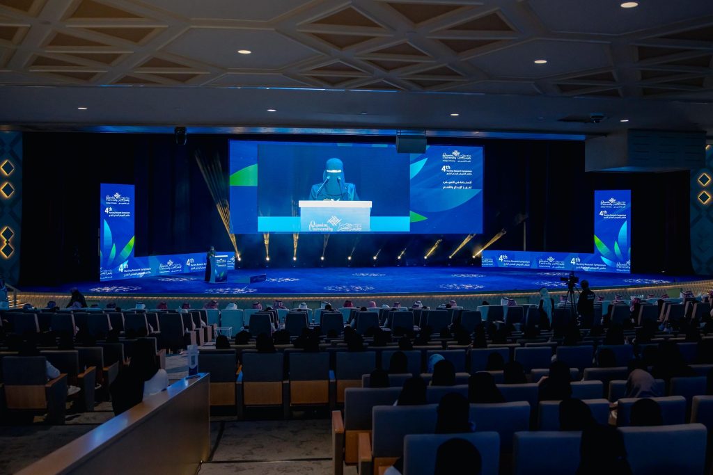 متحدثة تقدم عرضاً بحثاً حول الاستدامة والإبداع في تمريض جامعة القصيم بمؤتمر أكاديمي.