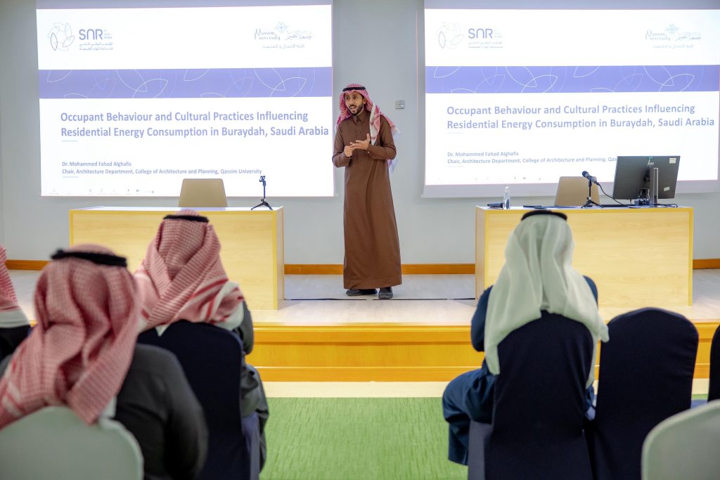 A faculty member presents a scientific lecture on energy consumption at Qassim University.