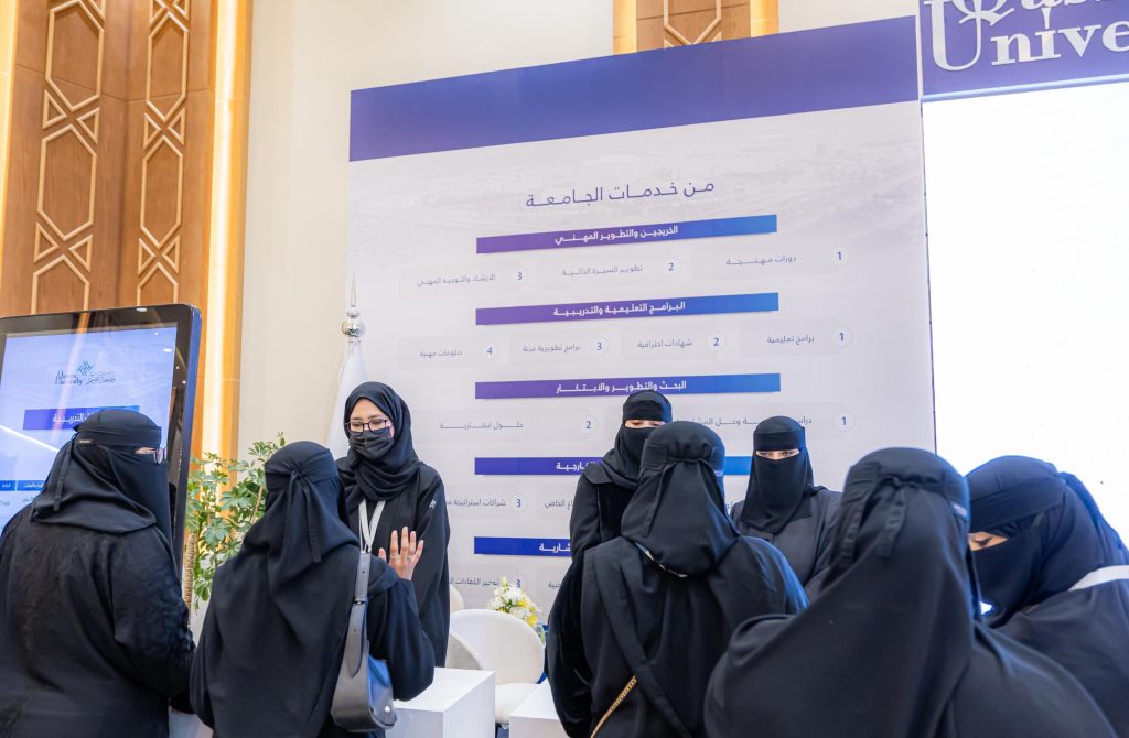 نقاش لطالبات جامعة القصيم أمام جناح جناحتي ضمن فعالية أكاديمية.