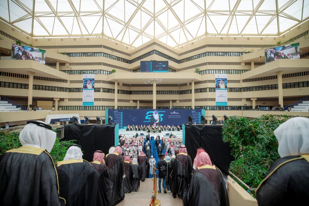 حفل تخرج رسمي في جامعة القصيم يُقام في قاعة حديثة بتجهيزات تقنية متقدمة.