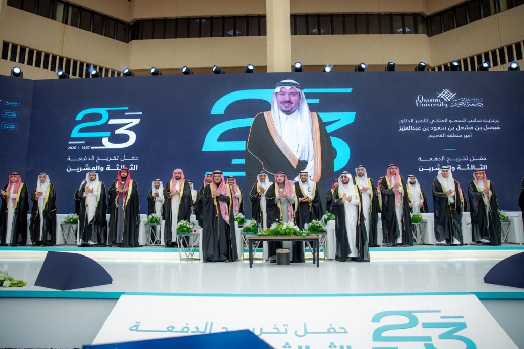 حفل تخرج خريجي جامعة القصيم بحضور أعضاء الجامعة، وشاشة تعرض أحد المكرمين.