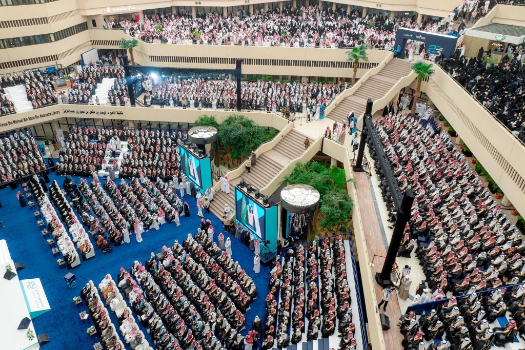 قاعة كبرى في جامعة القصيم تحتضن حفل التخرج، بتنظيم أكاديمي وجمعيات مجتمعية.