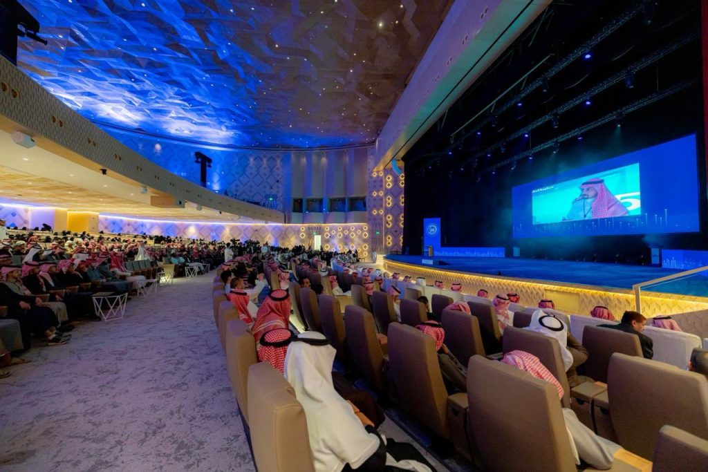 ملتقى التحول الرقمي بجامعة القصيم بحضور أكاديمي في قاعة عصرية واسعة.