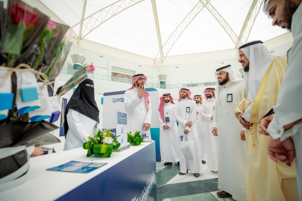 We are about an introductory booth at a Qassim University College of Medicine event under a white dome.
