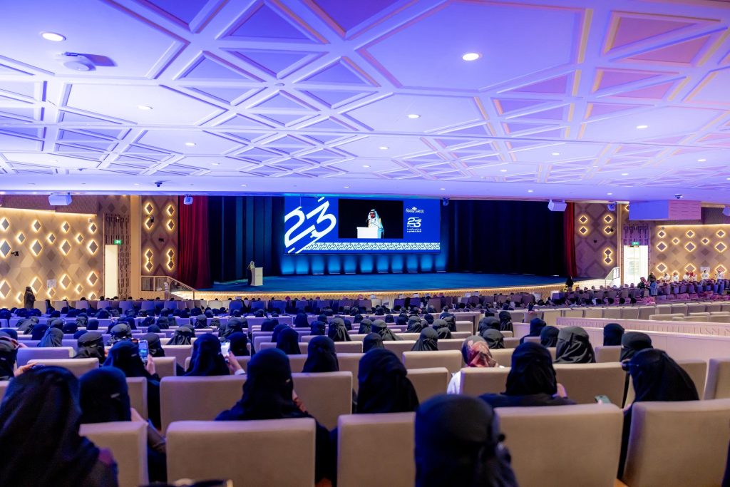 تخرج حفل تخرج رسمي بجامعة القصيم مع عرض شعار المناسبة والدفعة الثالثة والعشرون على الشاشة.