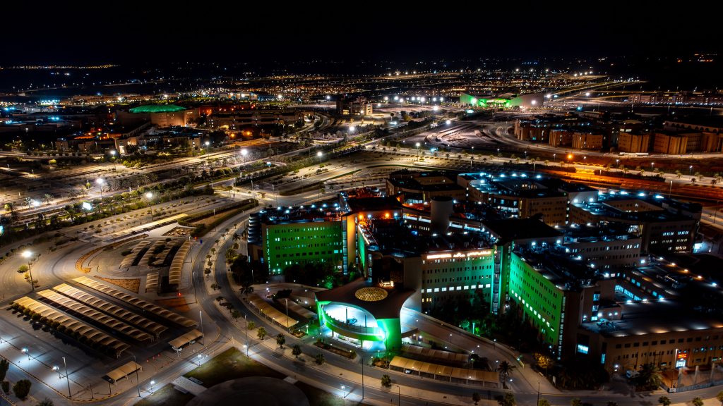 A nighttime view of a lighted city to commemorate Foundation Day at Qassim University.