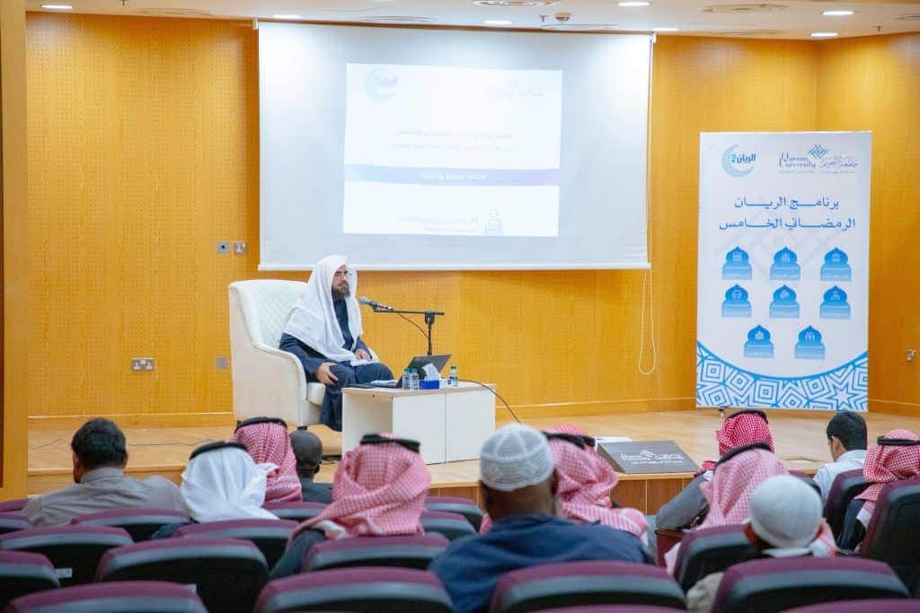 عرض فعاليات فعاليات الريان الرماني في جامعة القصيم بحضور أكاديمي وجمهور في قاعة حديثة.