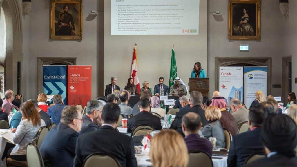 An academic conference for Qassim University on partnership, with a speaker present in an official hall.