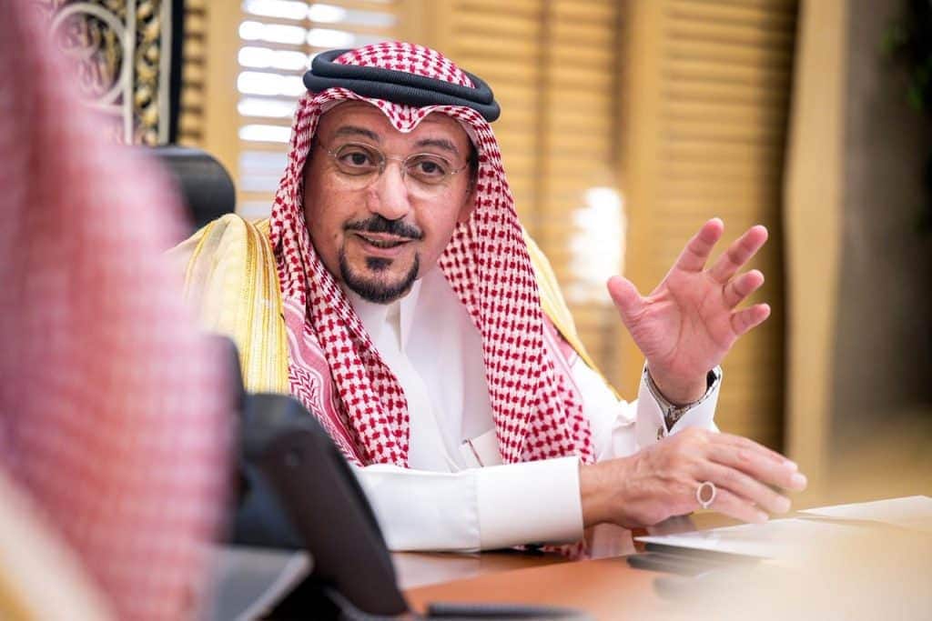 A faculty member discusses university programs in his office at Qassim University within a Saudi academic environment.