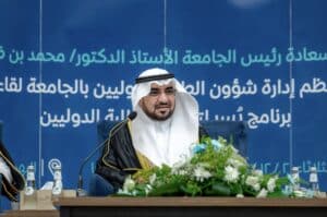 مسؤول في جامعة القصيم يتحدث في مؤتمر أكاديمي عن شؤون الجامعة.