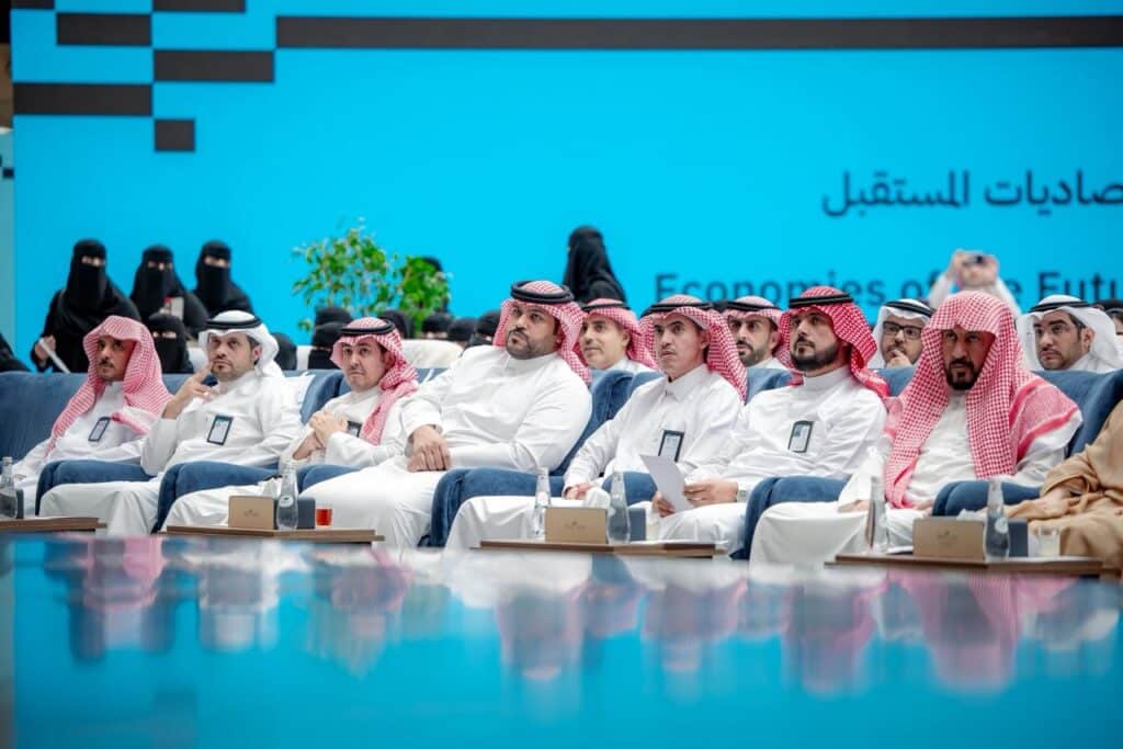 Official academic presence at the Research and Innovation Conference 2026, Qassim University, with a backdrop screen.