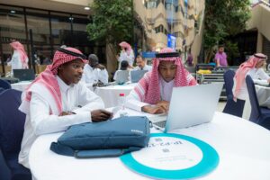 مشاركون في ورشة أكاديمية بجامعة القصيم يتعاونون في قاعة حديثة.