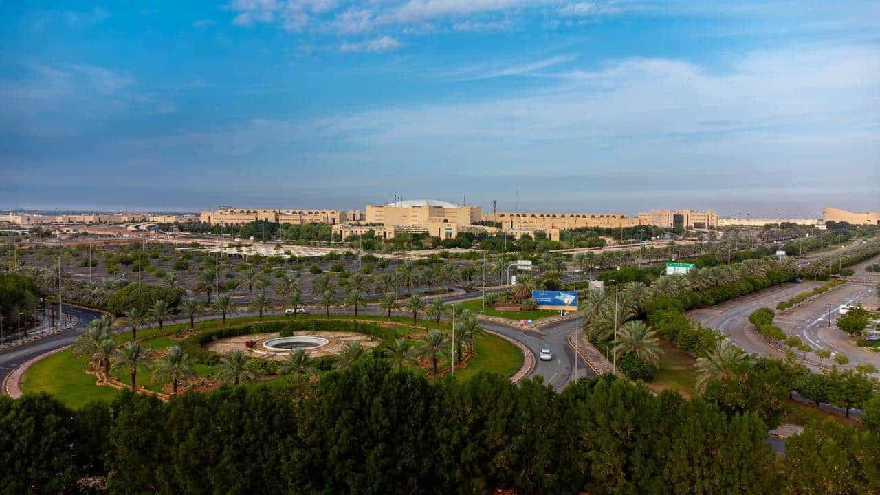 A panoramic view of the Qassim University entrance reflects a vibrant Saudi academic atmosphere.