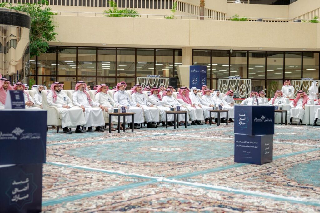 حضور منسوبي جامعة القصيم لفعالية عيد الأضحى في قاعة داخلية بأجواء اجتماعية رسمية.