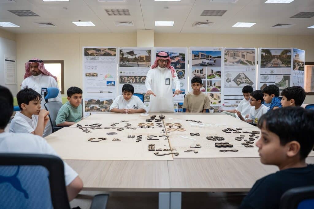 نشاط طلابي تعاوني حول مشروع هندسي في قاعة دراسية بجامعة القصيم.