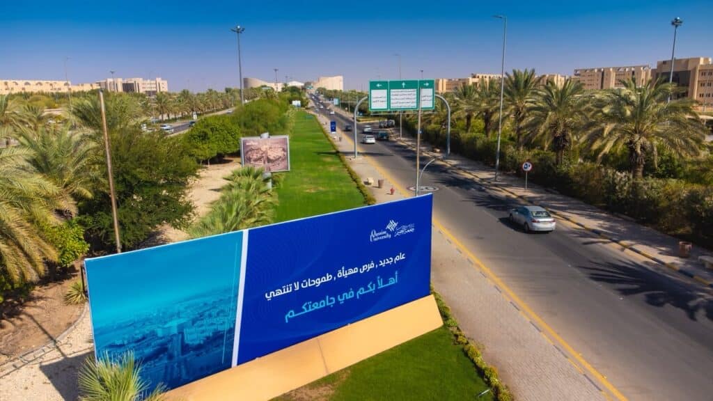 مدخل جامعة القصيم مع لافتة ترحيبية تحت سماء صافية، وبداية عام دراسي جديد.