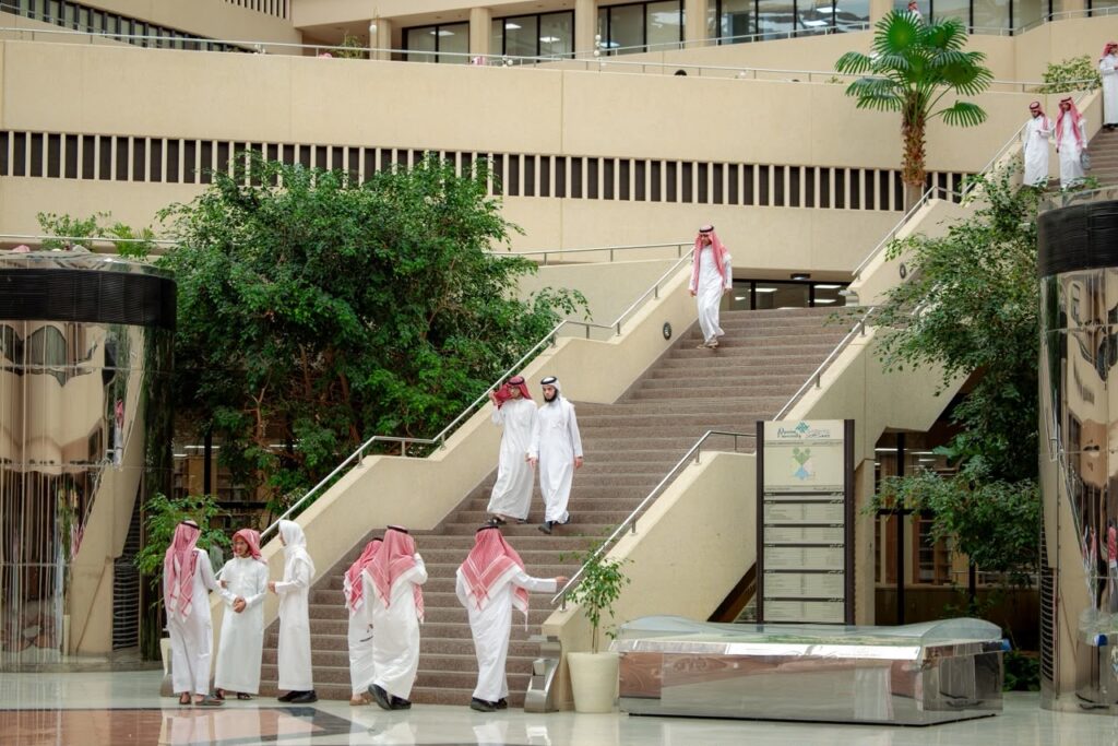 عدد من الطلاب يتبادلون الأحاديث في ردهة حديثة بجامعة القصيم مع بداية العام الدراسي.