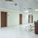 A lit and quiet indoor corridor in one of the student housing building lobbies at Qassim University.