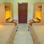One of the student dormitory rooms at Qassim University, accommodating two persons and containing a bed, a desk unit, and a wardrobe for each of them.