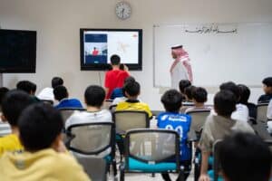 طلاب يتفاعلون مع درس علمي تفاعلي في إحدى قاعات جامعة القصيم، ضمن الأنشطة الصيفية.