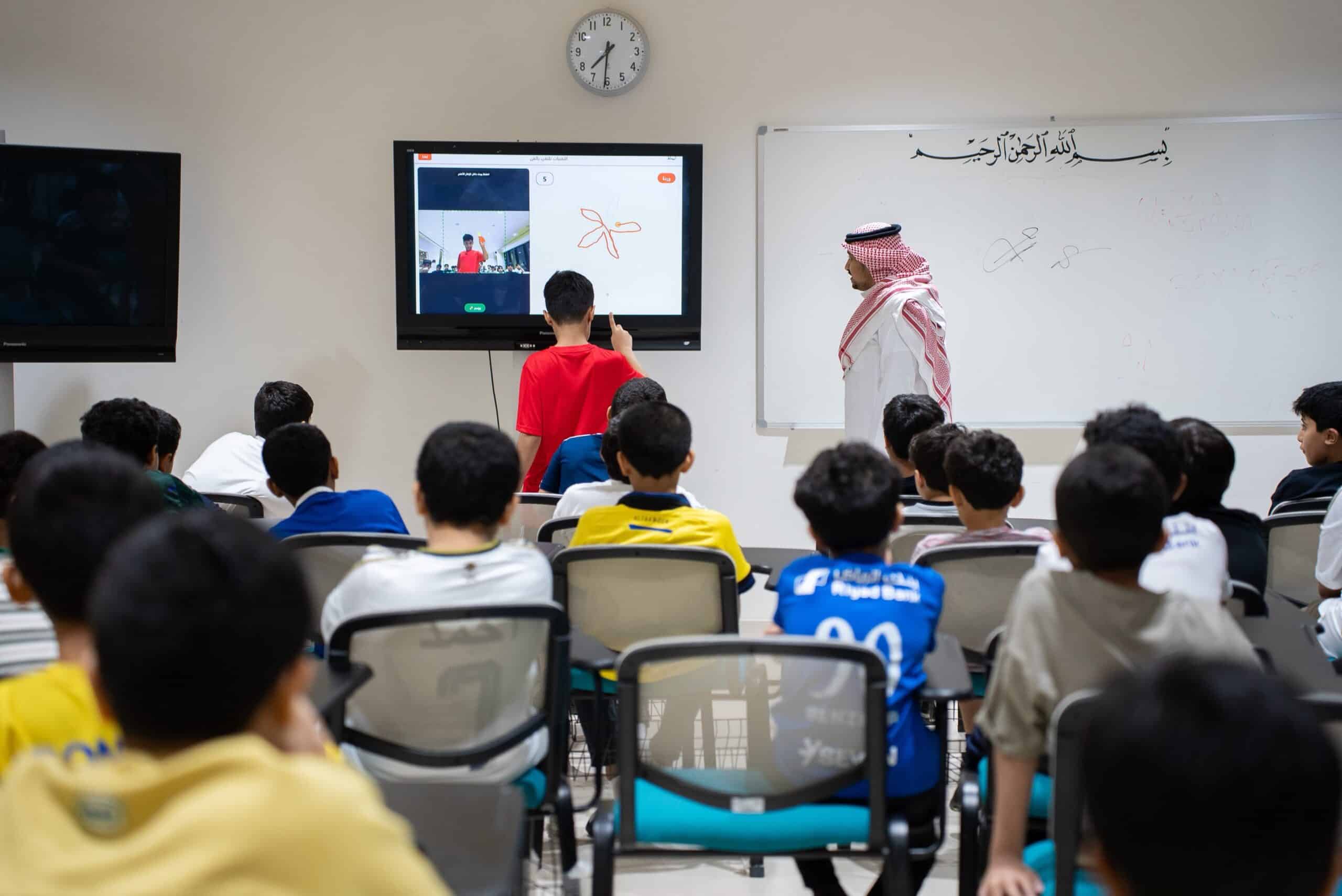 طلاب يتفاعلون مع درس علمي تفاعلي في إحدى قاعات جامعة القصيم، ضمن الأنشطة الصيفية.