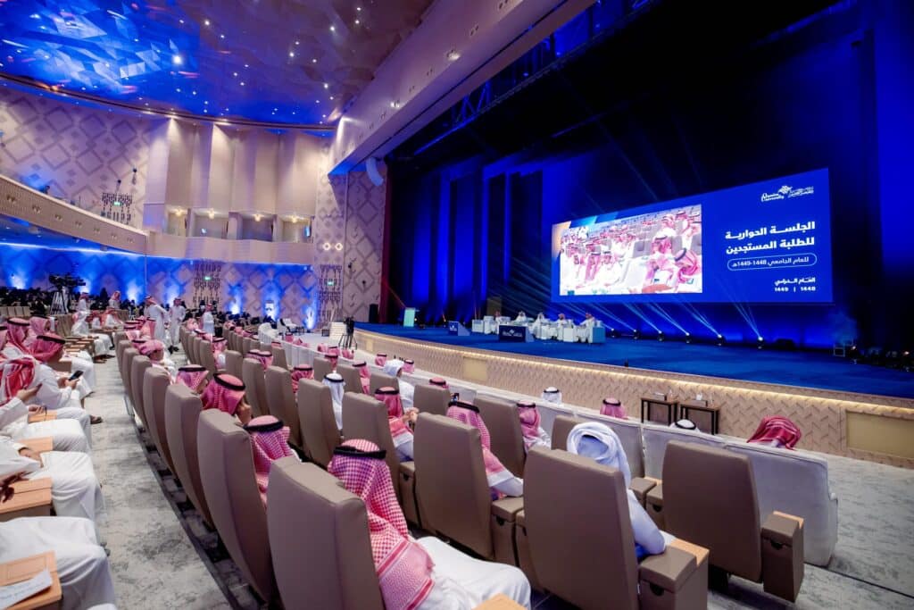 The Qassim University conference hall is hosting an academic discussion panel in the presence of new students.
