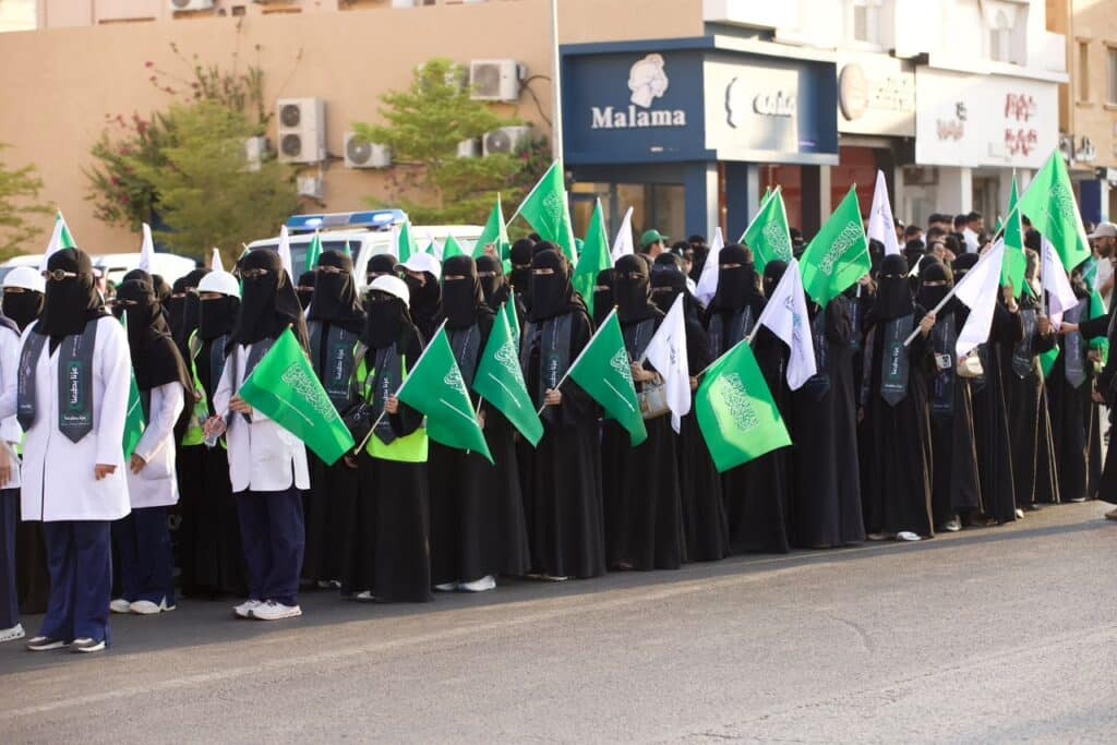 احتفال باليوم الوطني في أحد شوارع بريدة، بمشاركة نسائية تمثل جامعة القصيم.