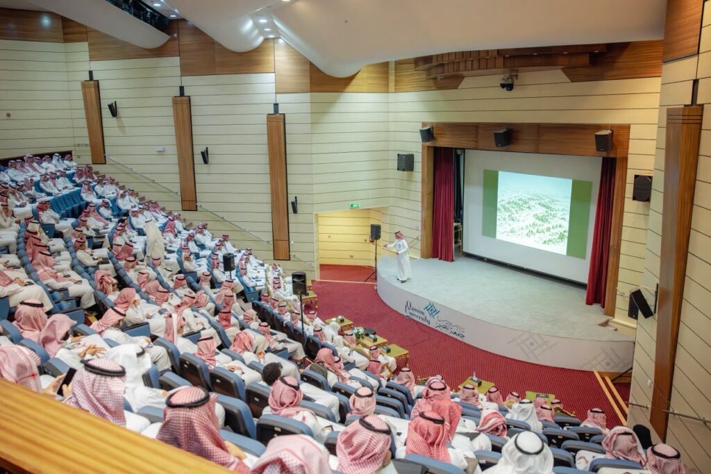 قاعة محاضرات بجامعة القصيم أثناء عرض أكاديمي تفاعلي أمام الحضور.