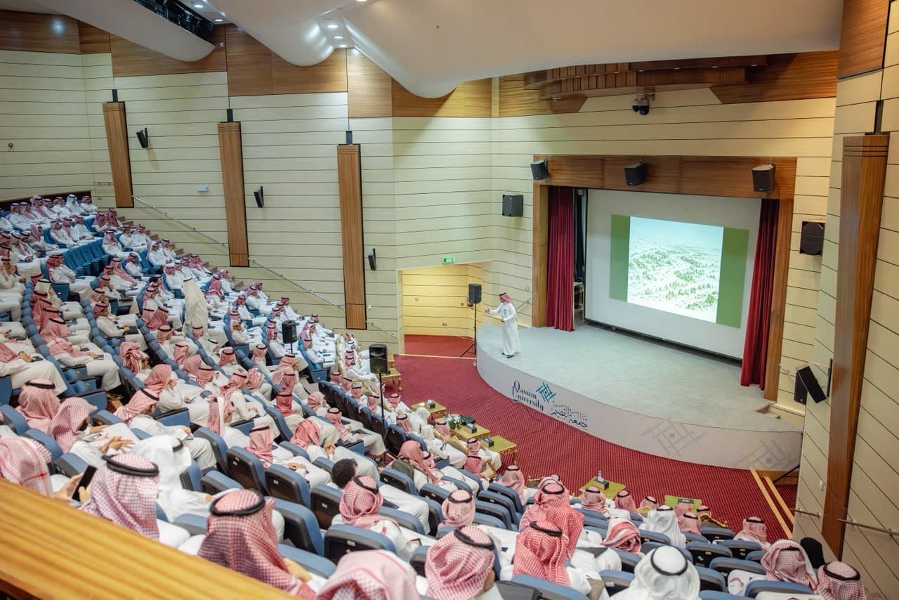 قاعة محاضرات بجامعة القصيم أثناء عرض أكاديمي تفاعلي أمام الحضور.