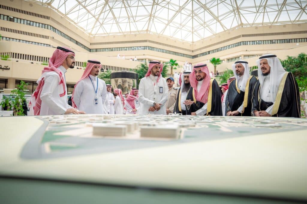 اجتماع أكاديمي بجامعة القصيم حول نموذج معماري في معرض كلية العمارة.