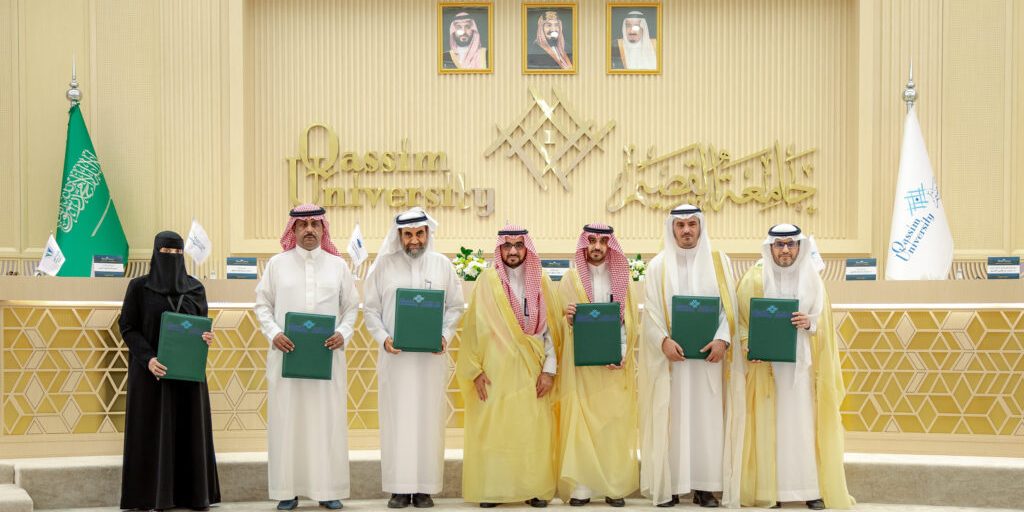 An academic memorandum of understanding between Qassim University and an educational institution in the presence of official representatives.