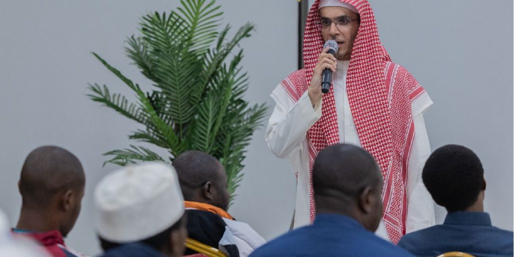 إحدى فعاليات جامعة القصيم، متحدثًا يقدم عرضًا حضورًا أمام قاعة مخصصة للندوات.